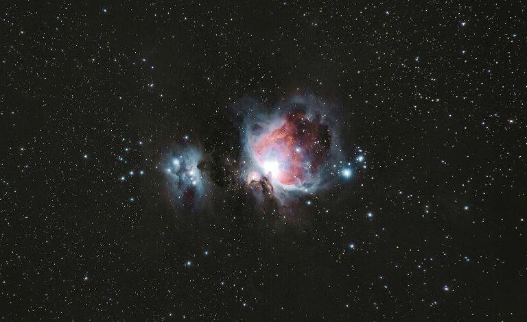 A breathtaking photograph of the Orion Nebula amidst a starry night sky, capturing celestial beauty.