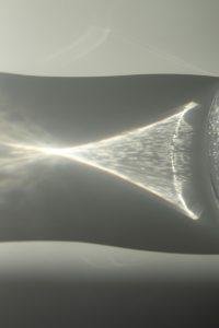 Subtle play of light reflections and shadows creating an abstract visual on a glass surface.