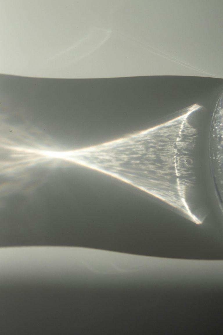 Subtle play of light reflections and shadows creating an abstract visual on a glass surface.