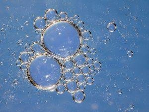Macro shot of delicate water bubbles in sunlight, showcasing a clear and circular pattern.
