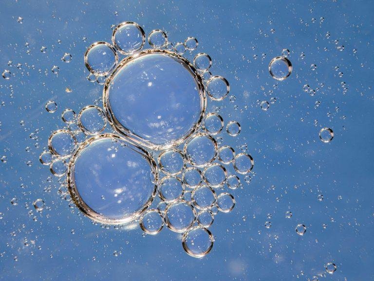 Macro shot of delicate water bubbles in sunlight, showcasing a clear and circular pattern.